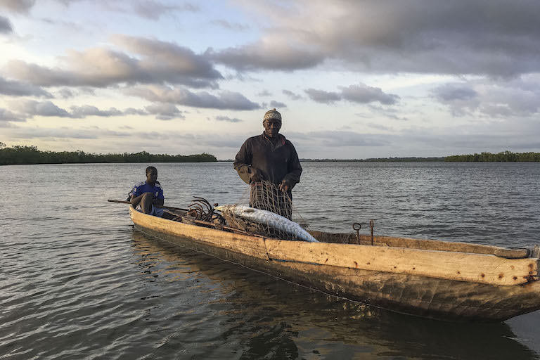 A fisherman pulls in a barracuda at sunset on the waters of the Casamance River, accompanied by an apprentice. Image by Jennifer O’Mahony for Mongabay.